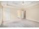 Bright primary bedroom with a tray ceiling, carpet, and an ensuite bathroom at 602 Jules Crest Ct, Lawrenceville, GA 30045