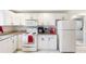 Bright kitchen features white cabinets, modern appliances, granite countertops, and access to the laundry room at 1087 Longley Nw Ave, Atlanta, GA 30318