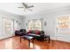 Bright living room with hardwood floors, modern ceiling fan and gray walls and leather couch at 1091 Longley Nw Ave, Atlanta, GA 30318