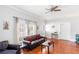 Cozy living room featuring a leather sofa with red pillows, ceiling fan, and wood-look flooring at 1091 Longley Nw Ave, Atlanta, GA 30318