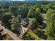 Aerial view of a charming home with mature trees on a spacious lot, complete with a long driveway at 1875 Bernice Dr, Cumming, GA 30041