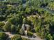 Aerial view of a neighborhood featuring tree-lined streets, homes, and a lake at 1875 Bernice Dr, Cumming, GA 30041