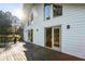 Back deck of a house with multiple doors leading into the house, overlooking a sunny backyard at 1875 Bernice Dr, Cumming, GA 30041