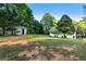 Backyard featuring a lawn, a detached garage, a two-story home, and many mature trees at 1875 Bernice Dr, Cumming, GA 30041