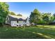 Picture of a grassy backyard with a two-story home, chimney, and lots of mature trees at 1875 Bernice Dr, Cumming, GA 30041