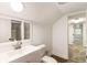 Modern bathroom with tiled floors, white vanity and framed mirror, and open doorway to bedroom at 1875 Bernice Dr, Cumming, GA 30041