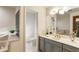 Bathroom with gray cabinets, double sinks, and a bathtub at 1875 Bernice Dr, Cumming, GA 30041