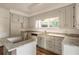 Bright kitchen with gray cabinets, granite countertops, stainless steel appliances, and wood floors at 1875 Bernice Dr, Cumming, GA 30041
