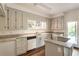 Bright kitchen with gray cabinets, granite countertops, stainless steel appliances, and wood floors at 1875 Bernice Dr, Cumming, GA 30041
