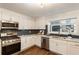 Well-lit kitchen features white cabinets, stainless steel appliances, modern backsplash, and hardwood floors at 1875 Bernice Dr, Cumming, GA 30041