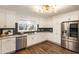 Well-lit kitchen features white cabinets, stainless steel appliances, modern backsplash, and hardwood floors at 1875 Bernice Dr, Cumming, GA 30041