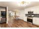 Modern kitchen adjacent to the dining area has white cabinets, stainless steel appliances, and hardwood floors at 1875 Bernice Dr, Cumming, GA 30041
