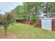 Home offers a spacious backyard with shed, wooden deck, patio seating, privacy fence, and mature trees at 3060 Baymount Dr, Lawrenceville, GA 30043
