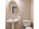 Bathroom featuring a pedestal sink, oval mirror, and updated fixtures and new toilet at 3060 Baymount Dr, Lawrenceville, GA 30043