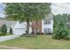 Traditional two-story home with a spacious front lawn, mature shade tree, and a two-car garage at 3060 Baymount Dr, Lawrenceville, GA 30043