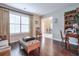 Elegant living room featuring hardwood floors, a cozy sofa, and ample natural light from a large window with curtains at 3060 Baymount Dr, Lawrenceville, GA 30043