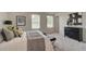 Bright bedroom features two large windows and neutral colors with a decorative black dresser at 1109 Georgian Point Dr, Lawrenceville, GA 30045