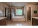 Bright bathroom featuring a large soaking tub, tiled floors, vanity with double sinks and a glass shower at 1185 Gallatin Way, Suwanee, GA 30024