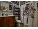 Bathroom featuring a wooden vanity, neutral tiling, and a tree-themed shower curtain at 1185 Gallatin Way, Suwanee, GA 30024