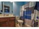 Cozy full bathroom with a wooden vanity, a toilet, and a shower with a patterned curtain at 1185 Gallatin Way, Suwanee, GA 30024