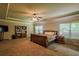 Spacious bedroom with tray ceilings, natural lighting, and a bookshelf filled with books at 1185 Gallatin Way, Suwanee, GA 30024