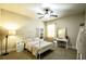 A bright bedroom with a decorative ceiling fan, white furniture, and a large window at 1185 Gallatin Way, Suwanee, GA 30024