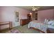 Pink bedroom with floral bedding, dresser, and an entrance to another room or closet at 1185 Gallatin Way, Suwanee, GA 30024