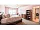 Well-lit bedroom with a bed, dresser, carpet, and a door to another room at 1185 Gallatin Way, Suwanee, GA 30024