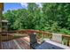 Outdoor deck featuring a table, chairs, and a view of the surrounding lush greenery at 1185 Gallatin Way, Suwanee, GA 30024