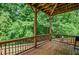 Outdoor deck with wooden railing and floor, surrounded by lush greenery, offering a peaceful retreat at 1185 Gallatin Way, Suwanee, GA 30024