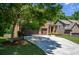 Long driveway leading to a brick home with a three-car garage and well-maintained landscaping at 1185 Gallatin Way, Suwanee, GA 30024
