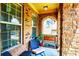 Cozy front porch with brick arches, seating, and plants, perfect for relaxation at 1185 Gallatin Way, Suwanee, GA 30024