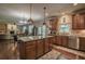 Open concept kitchen with island, wood cabinets and stainless steel appliances adjacent to Gathering room at 1185 Gallatin Way, Suwanee, GA 30024