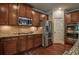 Kitchen featuring granite countertops, stainless steel appliances, and dark wood cabinetry with a double oven at 1185 Gallatin Way, Suwanee, GA 30024