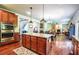 Open concept kitchen with island, stainless appliances, and view of living room and staircase at 1185 Gallatin Way, Suwanee, GA 30024