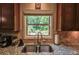 Kitchen sink with granite countertops, stainless steel appliances, and dark wood cabinetry at 1185 Gallatin Way, Suwanee, GA 30024