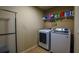 The laundry room has a new washer and dryer, tile flooring, and shelving for organized storage at 1185 Gallatin Way, Suwanee, GA 30024