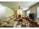 Spacious living room with a cozy fireplace, plush seating, and a ceiling fan at 1185 Gallatin Way, Suwanee, GA 30024