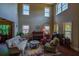 Bright living room with high ceilings and large windows showing sofa, chairs and a piano at 1185 Gallatin Way, Suwanee, GA 30024