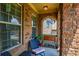 Cozy porch with brick columns and seating area, perfect for relaxing outdoors at 1185 Gallatin Way, Suwanee, GA 30024