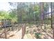 Wooded backyard with a trampoline, zipline and wooden fence bordering the property at 211 Aspen Valley Ln, Dallas, GA 30157