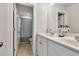 Bright bathroom featuring double sinks, white cabinets, tile floors, and decorative shower curtain at 211 Aspen Valley Ln, Dallas, GA 30157