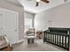 Cozy bedroom featuring a crib, comfortable chair with ottoman, and neutral decor at 211 Aspen Valley Ln, Dallas, GA 30157