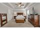 Spacious bedroom with tray ceilings, a ceiling fan, a king-size bed, and lovely wooden furniture at 211 Aspen Valley Ln, Dallas, GA 30157