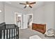 Neutral bedroom with a crib, dresser, and adjoining doors to bathroom and hallway at 211 Aspen Valley Ln, Dallas, GA 30157
