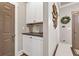 Hallway with storage cabinet, hardwood floors, and neutral paint color with sunburst decor at 211 Aspen Valley Ln, Dallas, GA 30157