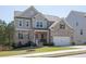A two-story home showcasing a blend of gray siding and brickwork with a neatly manicured lawn at 211 Aspen Valley Ln, Dallas, GA 30157