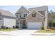 Well-kept lawn and a two-story brick and gray home featuring a front-facing two car garage at 211 Aspen Valley Ln, Dallas, GA 30157