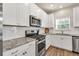 A well-lit kitchen with stainless steel appliances, granite countertops, and white subway tile at 211 Aspen Valley Ln, Dallas, GA 30157