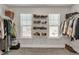 Spacious walk-in closet with organized shelving and rods for clothes and shoe storage, illuminated by two windows at 211 Aspen Valley Ln, Dallas, GA 30157